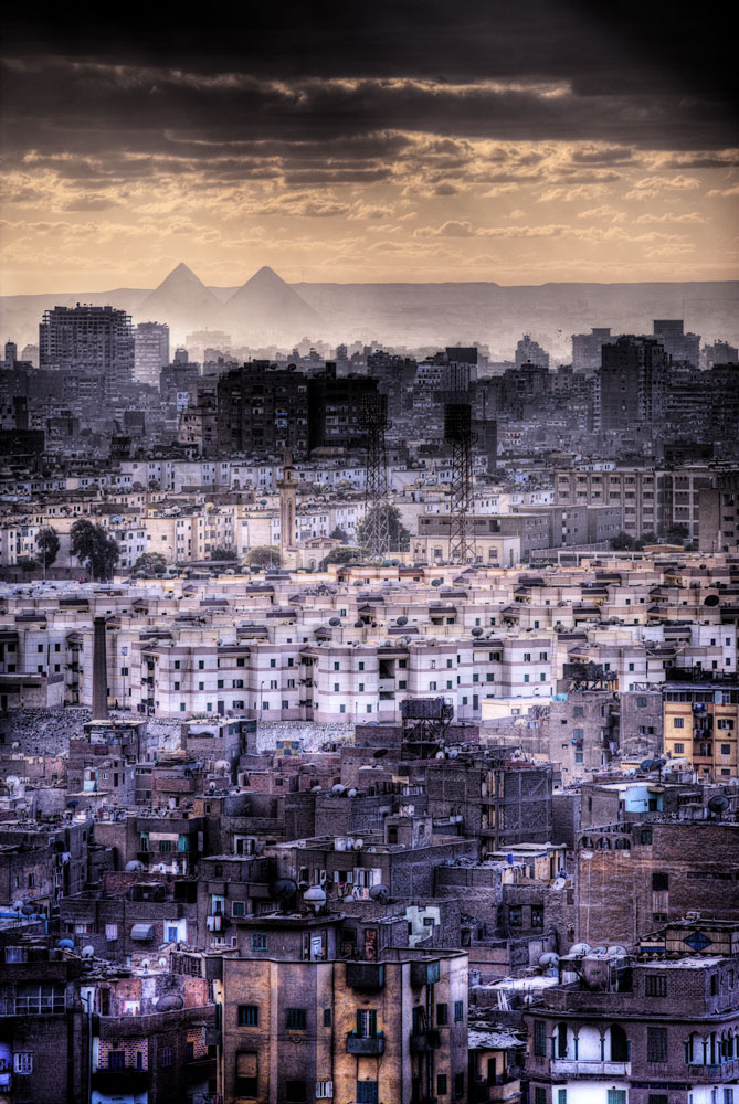 фотография современного застроенного Каира и древних пирамид Гизы на заднем плане