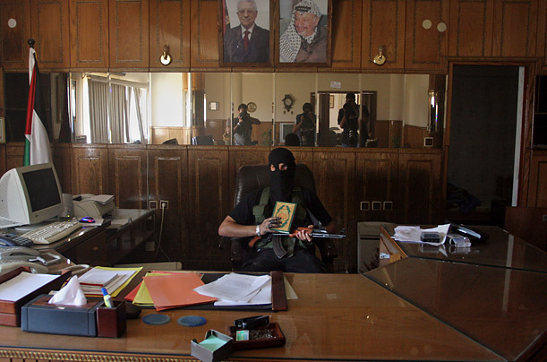 Боевик группировки ХАМАС сидит за столом в захваченном штабе сил безопасности группировки ФАТХ Сектор Газа