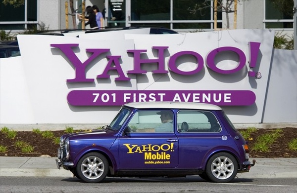 man drives a Mini Cooper with a Yahoo! logo in front of Yahoo! headquarters