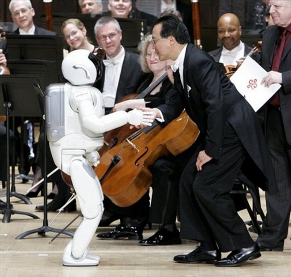Cellist Yo-Yo Ma, right, greets Honda's ASIMO robot after it conducted the Detroit Symphony Orchestr