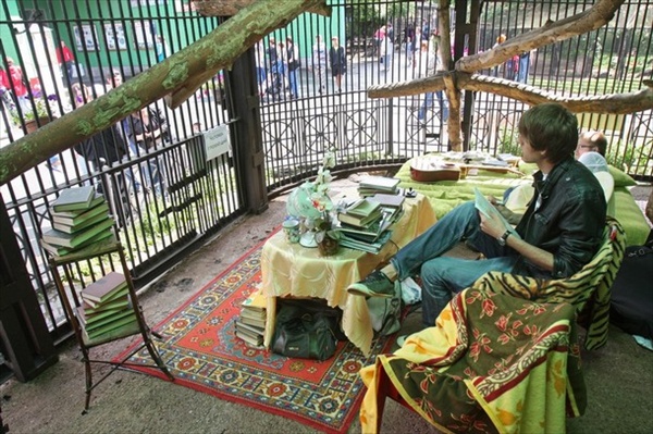 Человек читающий в клетке зоопарка Санкт-Петербурга