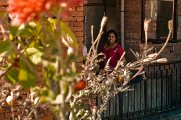 nepal_bhaktapur_woman_and_the_red_flower_on_a_roof_IMG_0266.jpg