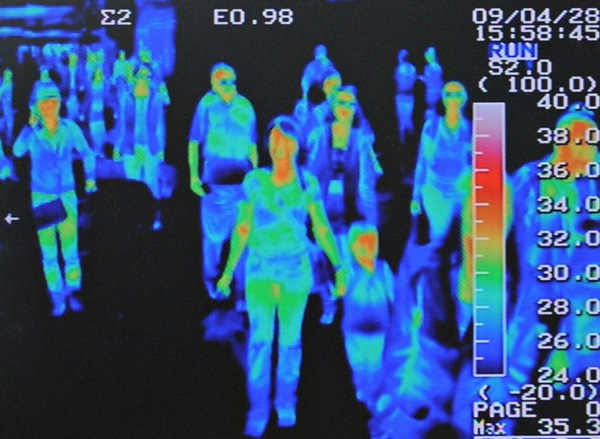 Тепловизионный сканер отслеживает повышение температуры у пассажиров международного рейса в сеульском аэропорту Инчеон