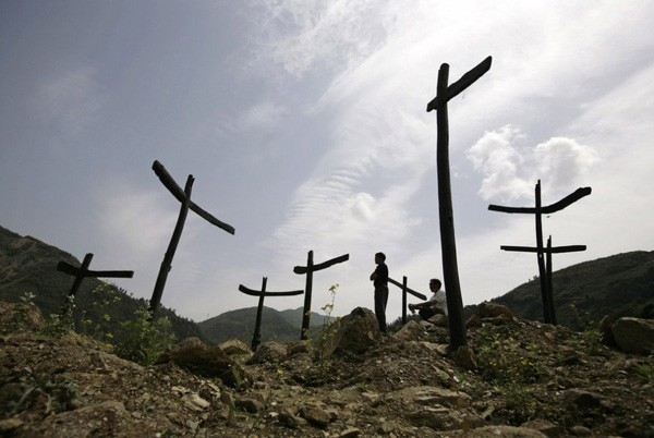 Выжившие после землетрясения на мемориале, возведенном в память о жертвах Сычуаньского землетрясения