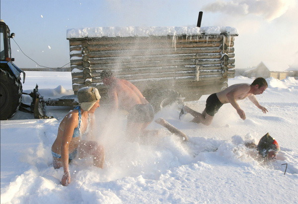 Люди резвятся в снегу после русской бани в деревне Бобровка к северу от Омска