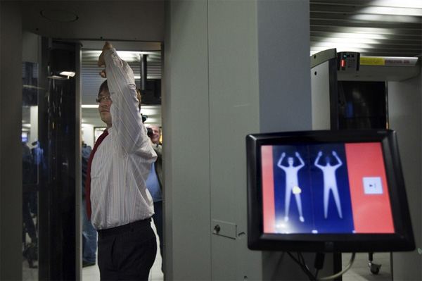 Служащий аэропорта Schiphol в Нидерландах демонстрирует использование сканера тела. Экран выдает тревожный сигнал при обнаружении спрятанных предметов