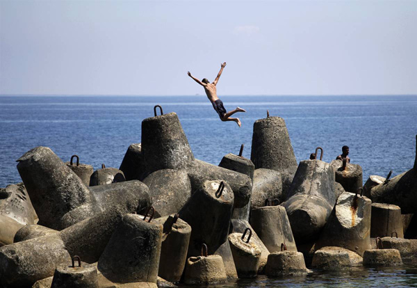 Юноша прыгает в океан в Гаване, Куба